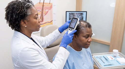 Trichologist examining a woman's scalp with a digital microscope